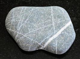 pebble of Graywacke sandstone on dark background photo