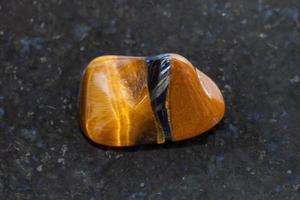 polished tiger eye gemstone on dark background photo