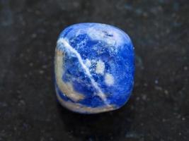 tumbled Sodalite gemstone on dark background photo