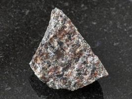 raw spreusteined urtite stone on dark photo