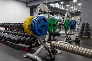 A closeup of weight plates and dumbbells in the sports complex photo