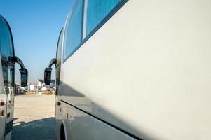 los autobuses de un turno de pasajeros se paran en una fila en un sitio de construcción foto