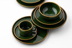 A set of dark green ceramic tableware with orange outlines photo