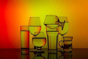 algunos vasos para diferentes bebidas apilados en un fondo colorido foto