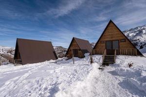 The wooden cottages surrounded by snow. A recreation area in the mountains photo