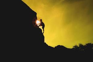 silueta de una mujer de negocios con banderas en la cima de una montaña sobre el cielo y la luz del sol foto