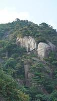 los hermosos paisajes montañosos con el bosque verde y el acantilado rocoso en erupción como fondo en el campo de china foto