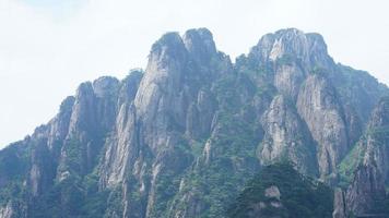 los hermosos paisajes montañosos con el bosque verde y el acantilado rocoso en erupción como fondo en el campo de china foto