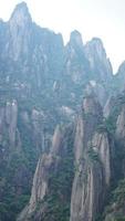 los hermosos paisajes montañosos con el bosque verde y el acantilado rocoso en erupción como fondo en el campo de china foto