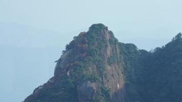 los hermosos paisajes montañosos con el bosque verde y el acantilado rocoso en erupción como fondo en el campo de china foto