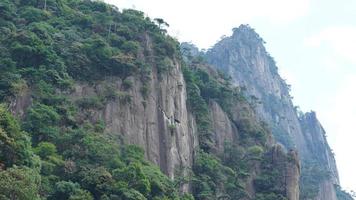 The beautiful mountains landscapes with the green forest and the erupted rock cliff as background in the countryside of the China photo