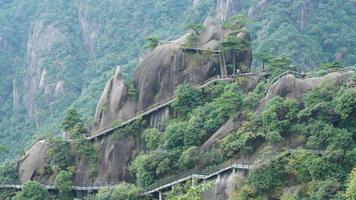The beautiful mountains landscapes with the green forest and a plank road built along the face of a cliff in the countryside of the China photo