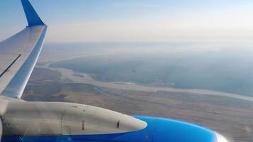 aereo volante al di sopra di il fiume. Visualizza a partire dal il oblò per il motore e ala video