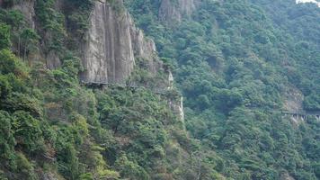 The beautiful mountains landscapes with the green forest and a plank road built along the face of a cliff in the countryside of the China photo