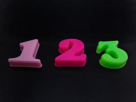 Close up of colorful numbers on a black background perfect for children's education photo