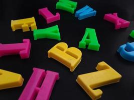 Close up of colorful alphabets on black background perfect for children's education photo