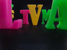 Close up of colorful alphabets on black background perfect for children's education photo