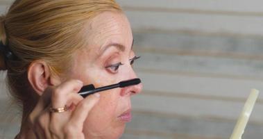 Age makeup. Applying mascara to eyelashe video