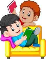 Two boy is reading book sitting on a big comfy chair vector