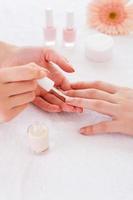 Making manicure. Close-up of beautician doing manicure to female customer photo