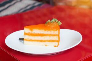 pastel de naranja en un plato blanco en el café foto