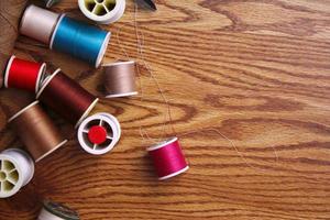 Multicolored threads and old scissors scattered on a wooden table, retro scissors, flat lay, copy space. photo