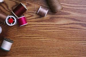 Multicolored threads and old scissors scattered on a wooden table, retro scissors, flat lay, copy space. photo