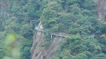 The beautiful mountains landscapes with the green forest and a plank road built along the face of a cliff in the countryside of the China photo