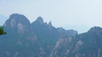 los hermosos paisajes montañosos con el bosque verde y el acantilado rocoso en erupción como fondo en el campo de china foto