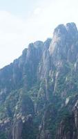 los hermosos paisajes montañosos con el bosque verde y el acantilado rocoso en erupción como fondo en el campo de china foto