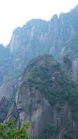 los hermosos paisajes montañosos con el bosque verde y el acantilado rocoso en erupción como fondo en el campo de china foto