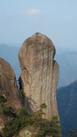 los hermosos paisajes montañosos con el bosque verde y el acantilado rocoso en erupción como fondo en el campo de china foto