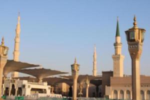 Medina, Saudi Arabia, Oct 2022 - A beautiful daytime view of Masjid Al Nabawi minarets and electronic umbrellas or canopies. photo