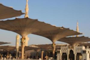 Medina, Saudi Arabia, Oct 2022 - A beautiful daytime view of Masjid Al Nabawi minarets and electronic umbrellas or canopies. photo