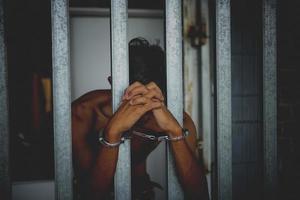 Hand of the prisoner on a steel lattice close up photo