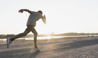 The silhouette of a man running is exercising the evening. photo