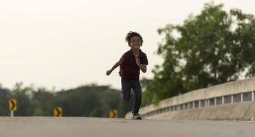 un niño pequeño corre a lo largo del puente. foto