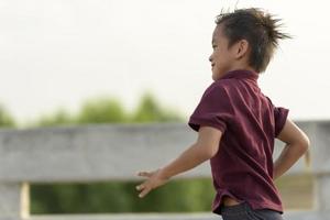 un niño pequeño corre a lo largo del puente. foto