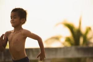 A strong little boy ran along the bridge. photo