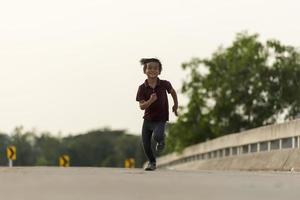 un niño pequeño corre a lo largo del puente. foto
