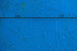 la textura del metal de hierro pintado de pintura azul en mal estado viejo en mal estado rayado agrietado antiguo muro de chapa de metal. el fondo foto