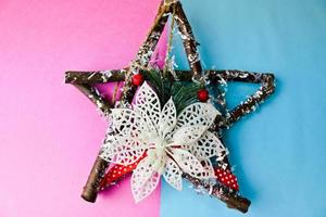 Large decorative beautiful wooden Christmas star, a self-made advent wreath of fir branches and sticks on the festive New Year happy blue-pink joyful background. Holiday decorations photo