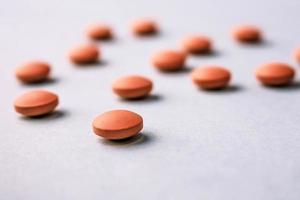 Small yellow orange beautiful medical pharmaceptic round pills, vitamins, drugs, antibiotics on a blue background, texture. Concept medicine, health care. Flat lay, top view photo