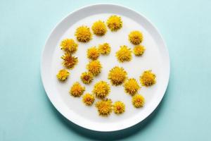 las flores amarillas del diente de león flotan en la leche blanca foto