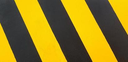 Black and yellow painted wall for background or wallpaper. Traffic line on floor or ground. photo