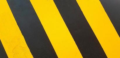 Black and yellow painted wall for background or wallpaper. Traffic line on floor or ground. photo