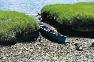 Canoe Pulled Up on a Rocky Shore Along a River photo