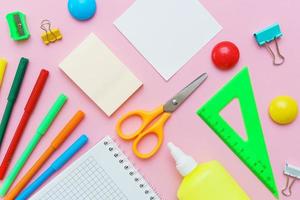 School supplies, stationery on pink background. Pens pencils notepad. Flat lay photo