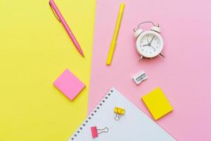 White notepad on spring and stationery school supplies on a pink background photo