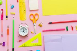 White notepad on spring and stationery school supplies on a pink background photo